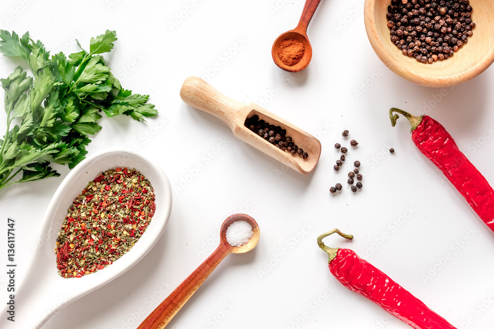 spices in wooden spoon on white background top view