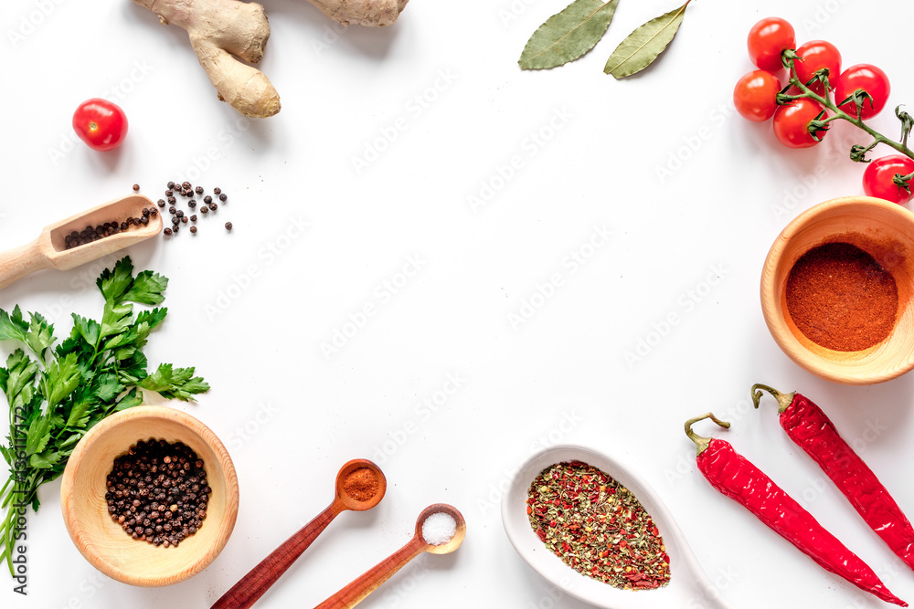 spices in wooden spoon on white background top view