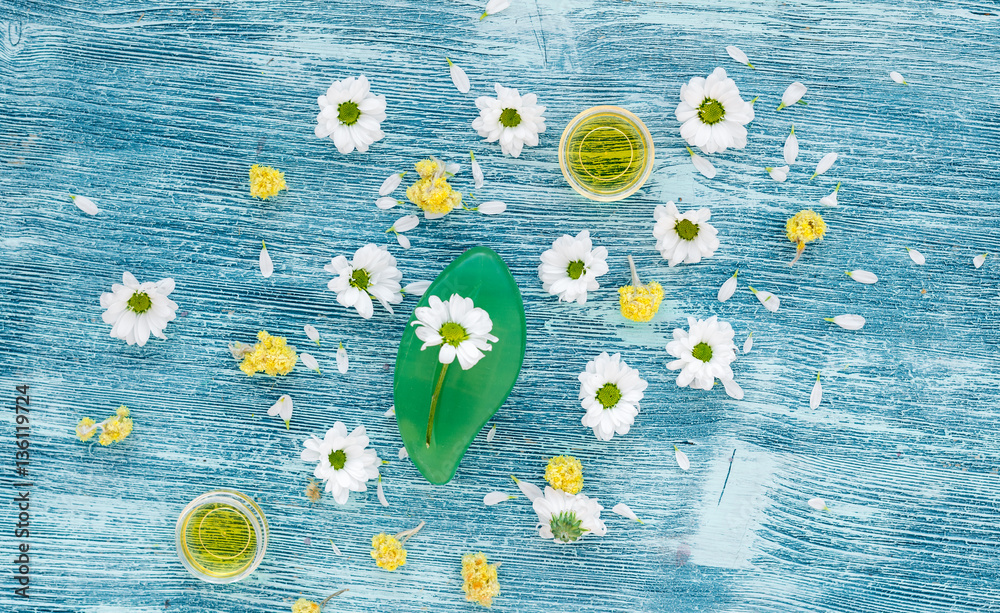 organic cosmetics with camomile on blue background top view