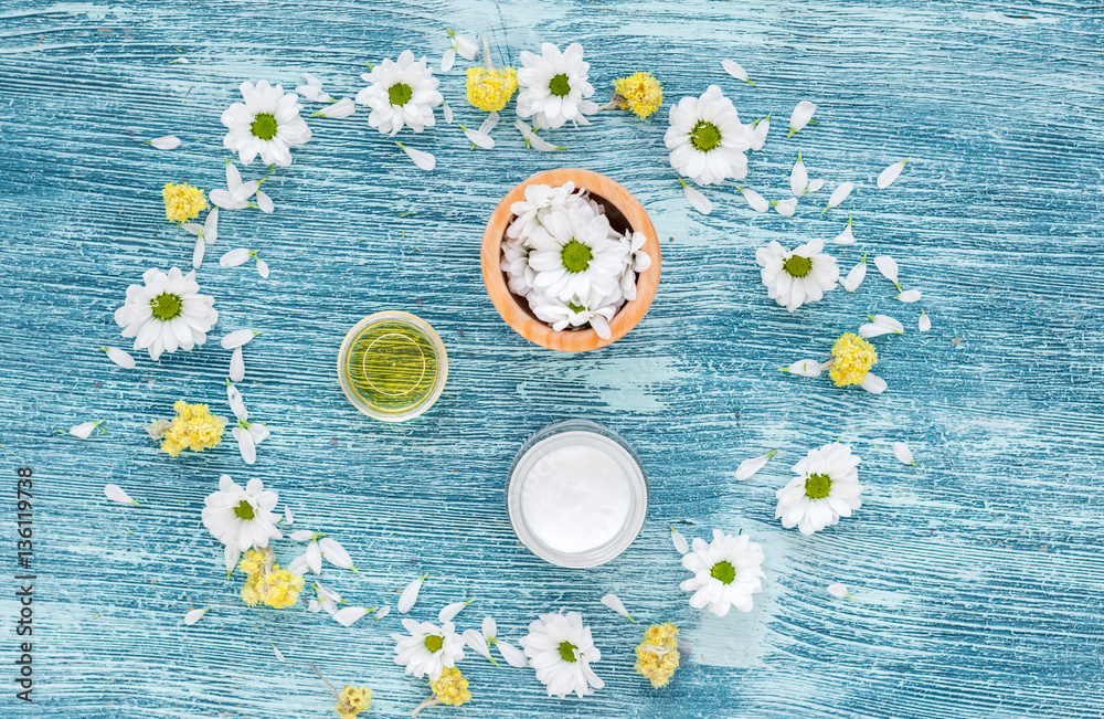 organic cosmetics with camomile on blue background top view