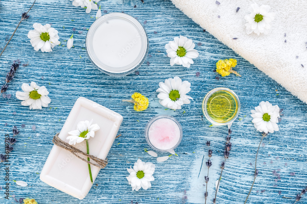 organic cosmetics with camomile on blue background top view