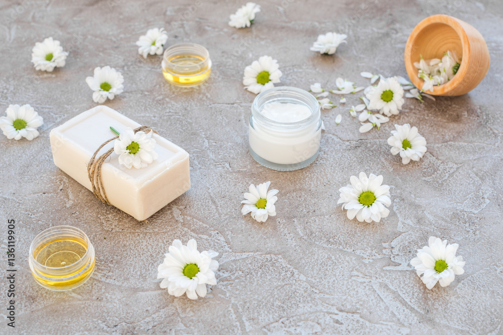 organic cosmetics with camomile on stone background