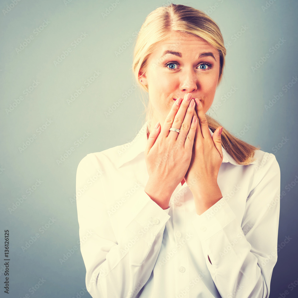 Young woman covering her mouth