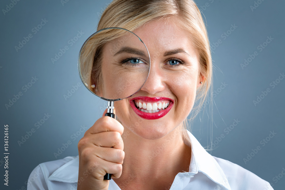 Woman looking through a magnifying glass