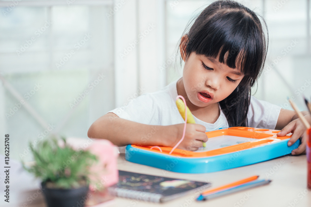 Little girl  playing with drawing  board