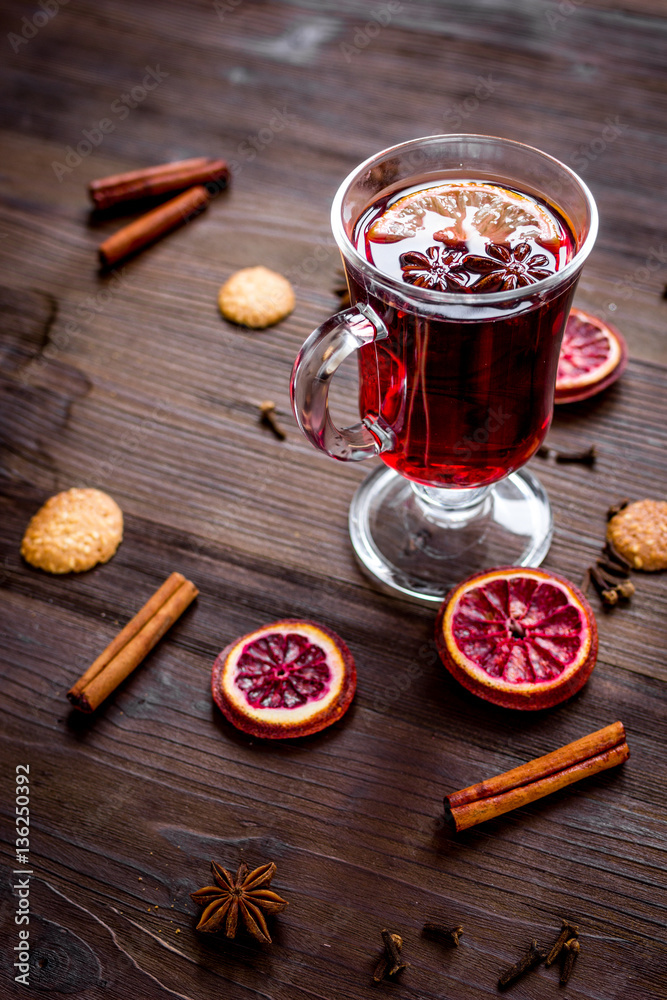 mulled wine with spices in cup on wooden background