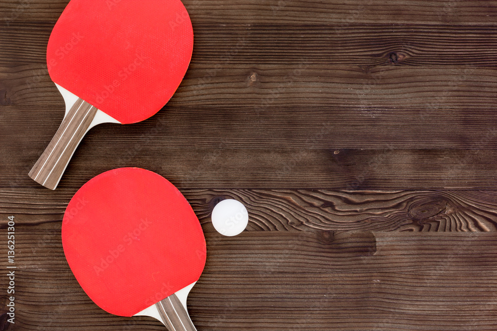 Red racket for ping pong ball wooden background top view