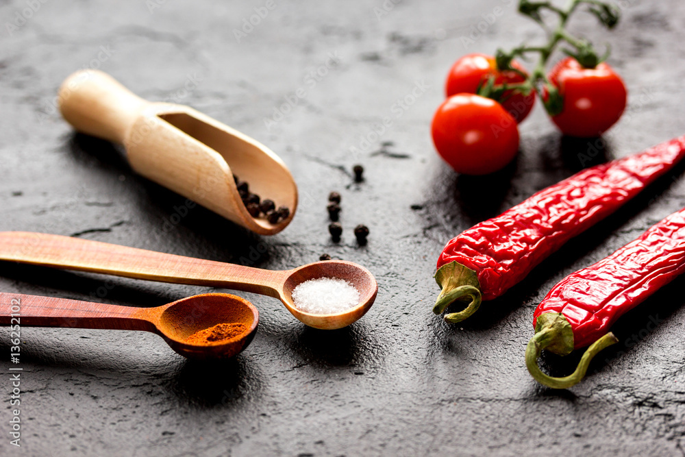 spices in wooden spoon on dark background