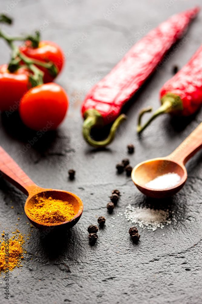 spices in wooden spoon on dark background