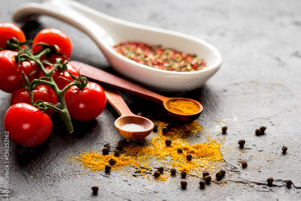 spices in wooden spoon on dark background