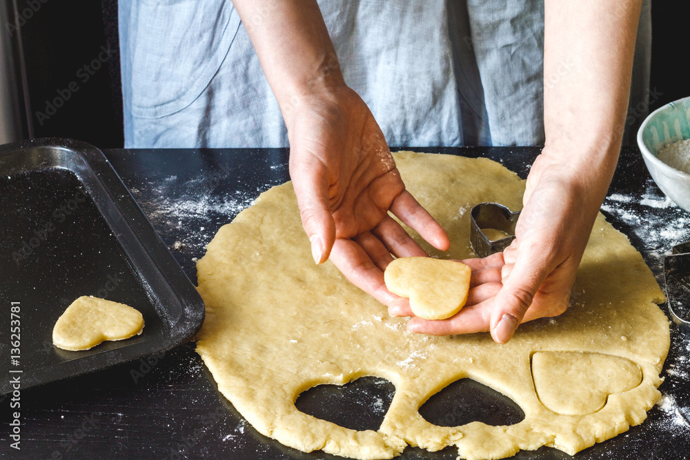 cooking homemade cookies with hands on dark background