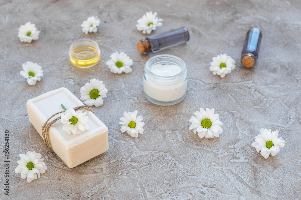 organic cosmetics with camomile on stone background