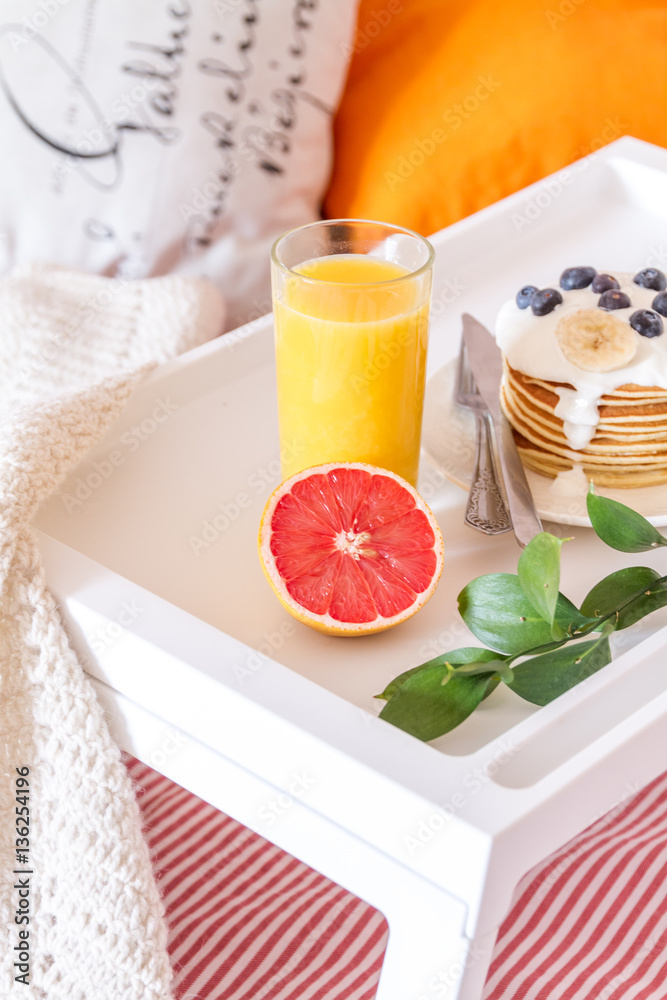 concept of breakfast in bed on tray with juice