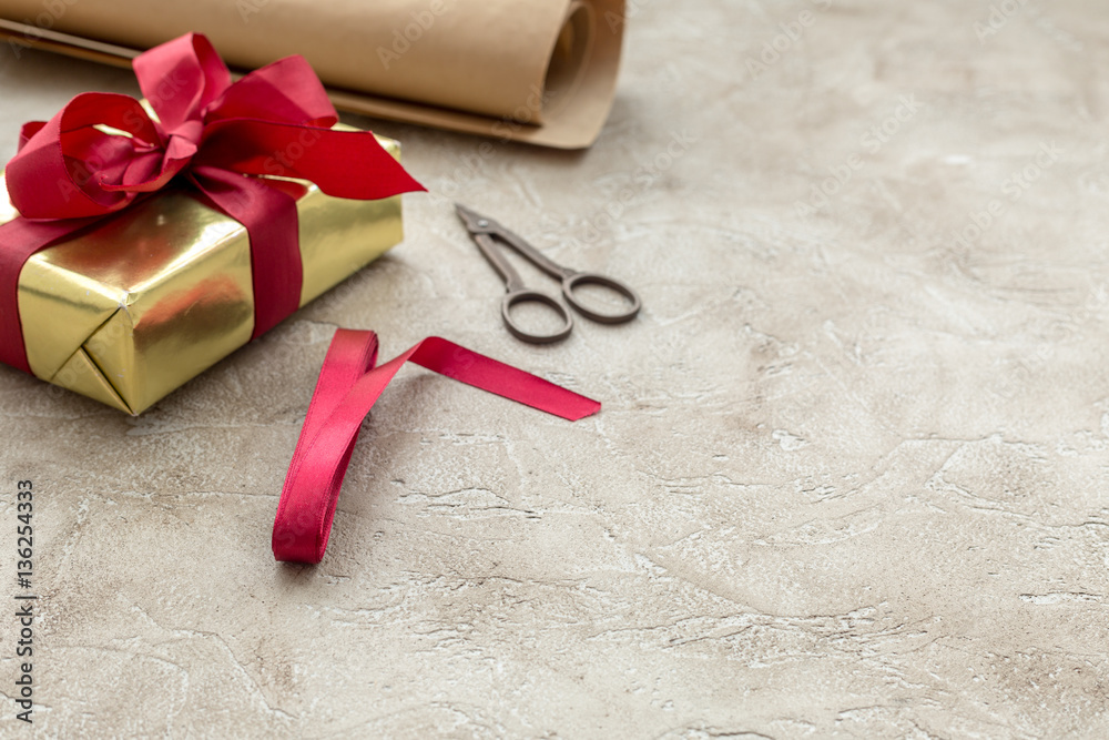 wrapping gifts in box for holiday on stone background