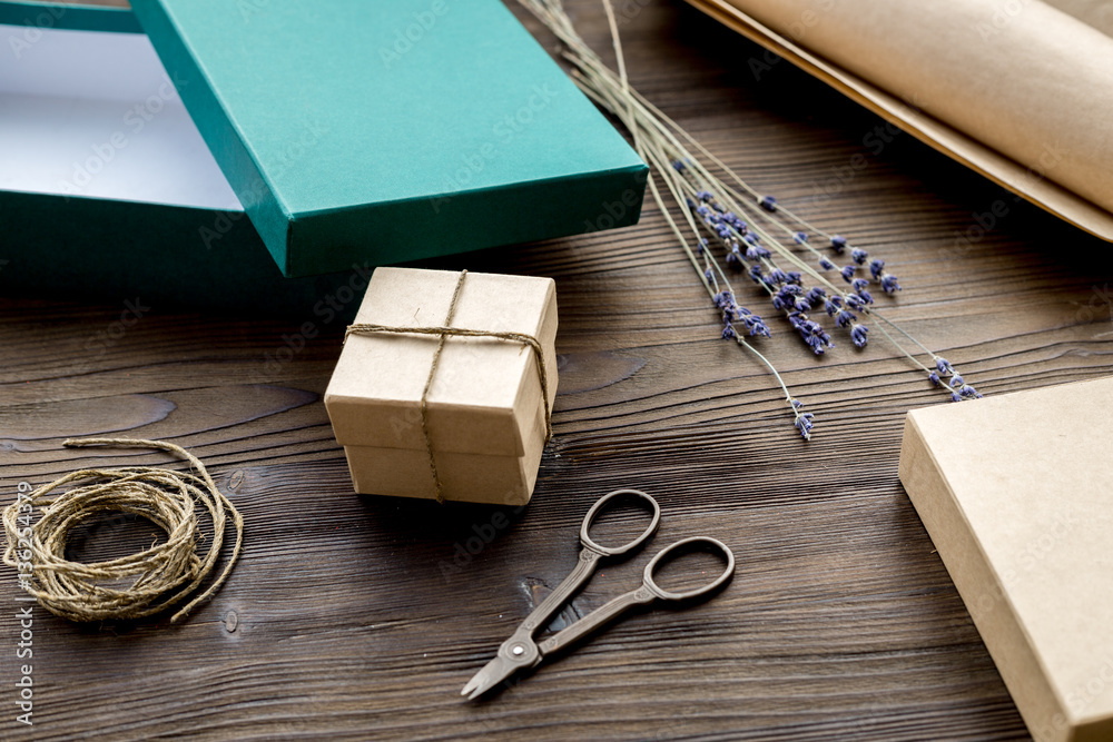 wrapping gifts in box for holiday on wooden background