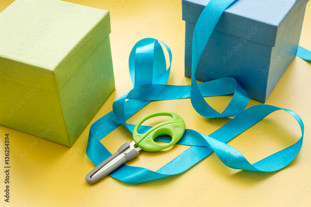 wrapping gifts in box for holiday on yellow background