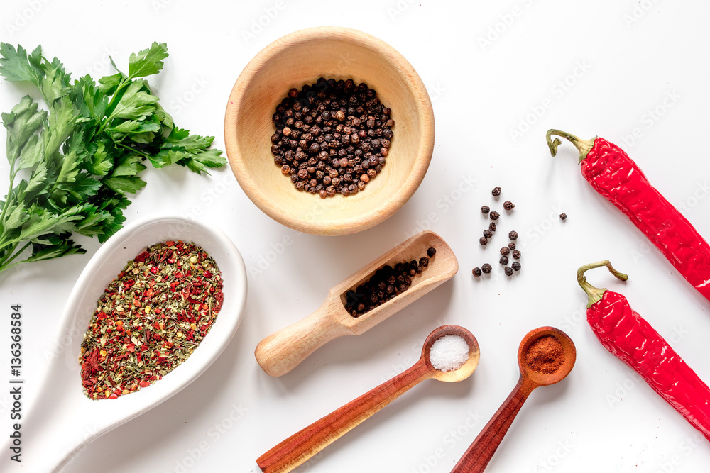 spices in wooden spoon on white background top view