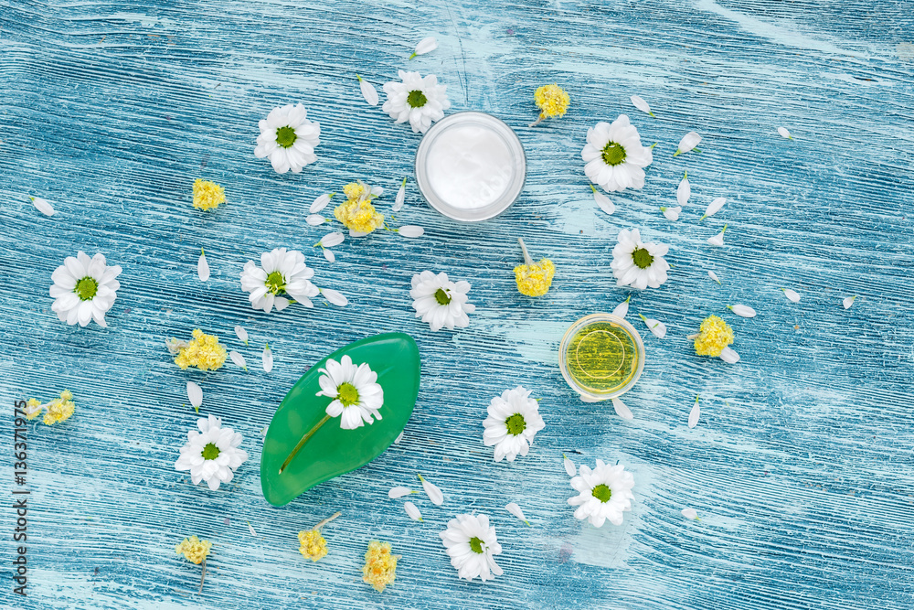 organic cosmetics with camomile on blue background top view