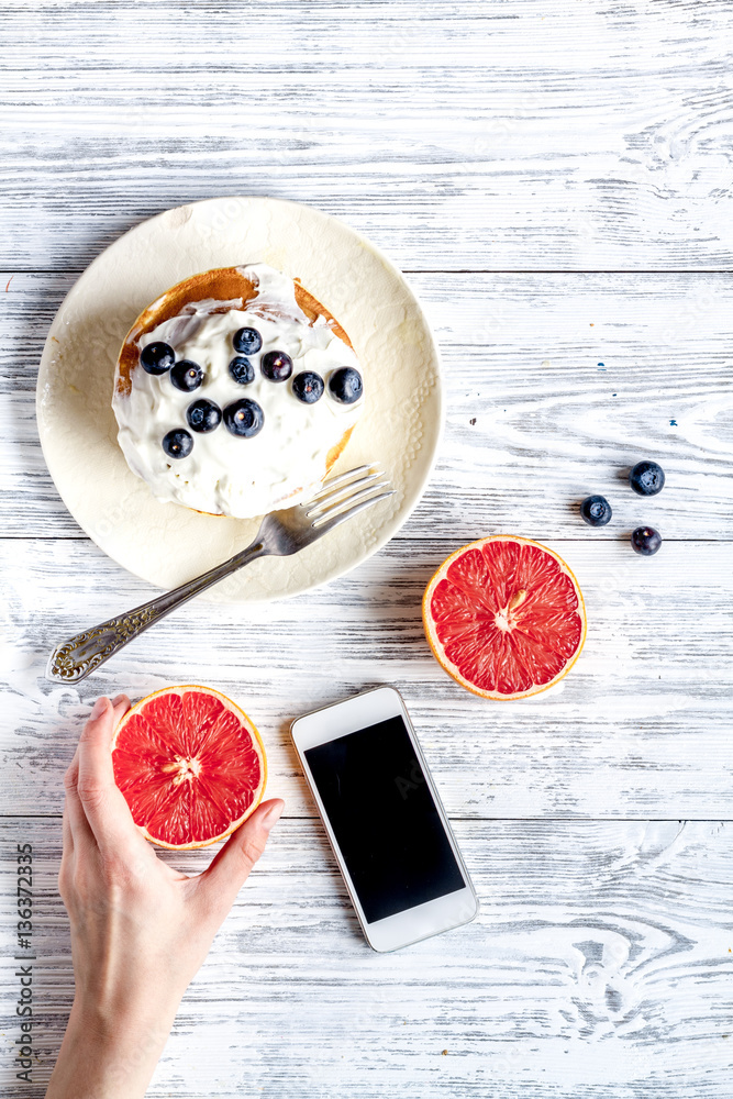 Breakfast concept with flowers on wooden background top view