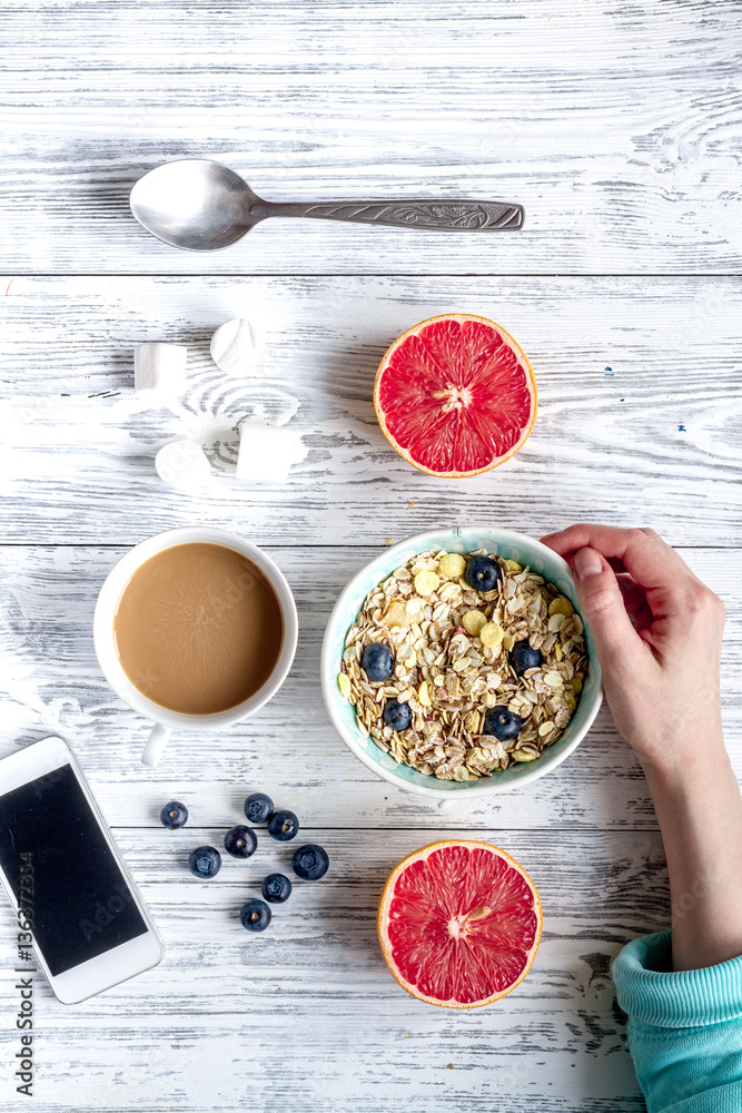 Breakfast concept with flowers on wooden background top view