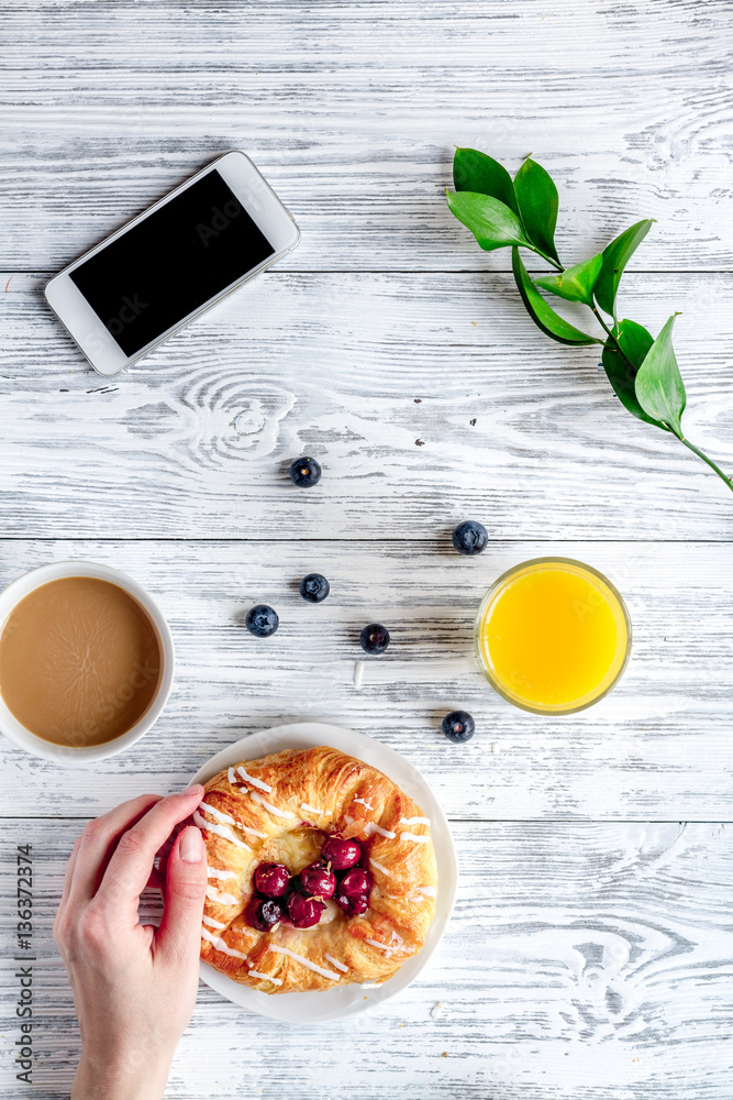 Breakfast concept with flowers on wooden background top view