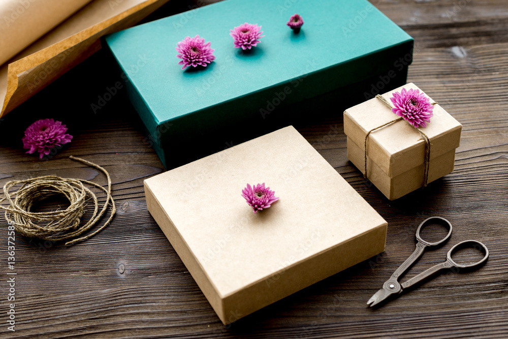 wrapping gifts in box for holiday on wooden background