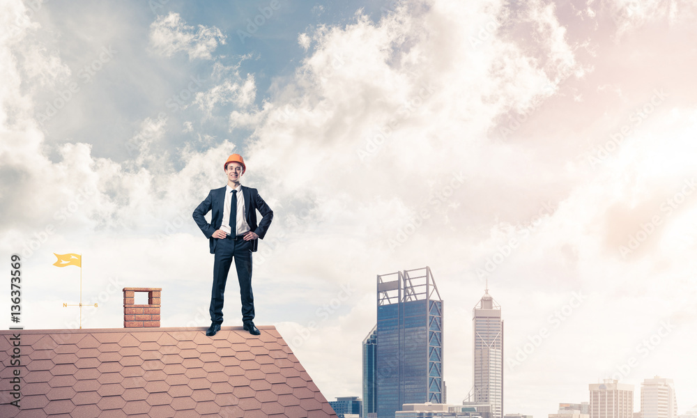 Engineer man standing on roof and looking away. Mixed media