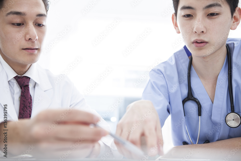 Two doctors are talking about treatment methods in the examination room