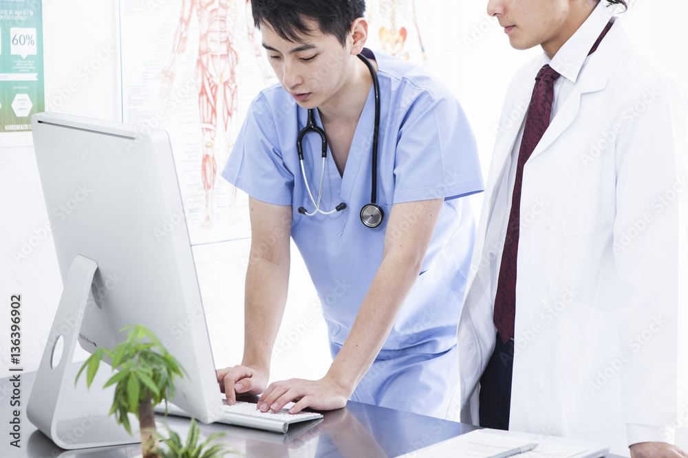 Two doctors are watching a computer together