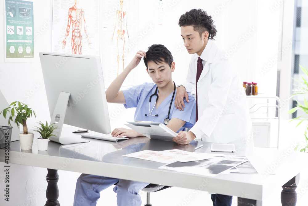 Two male doctors are talking at the examination room