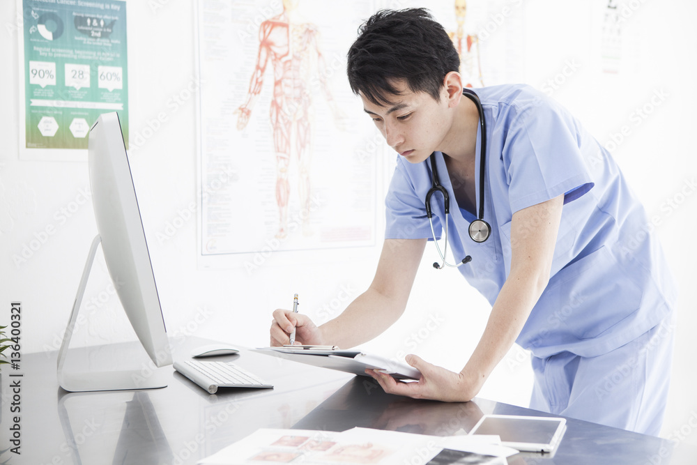 The doctor is watching the chart in the examination room