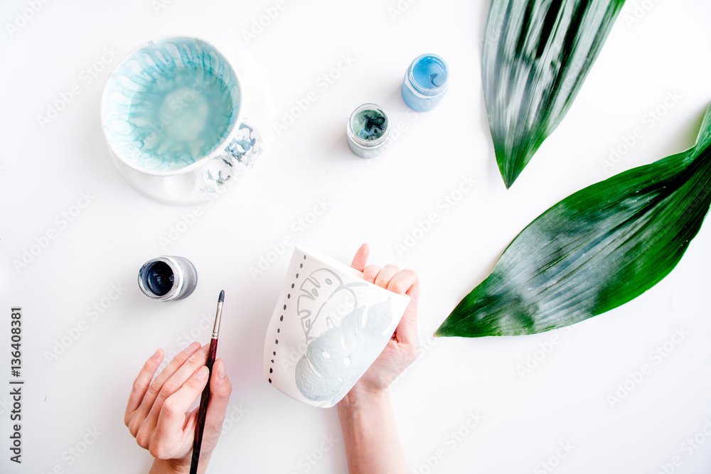 painted ceramic cup on white background top view