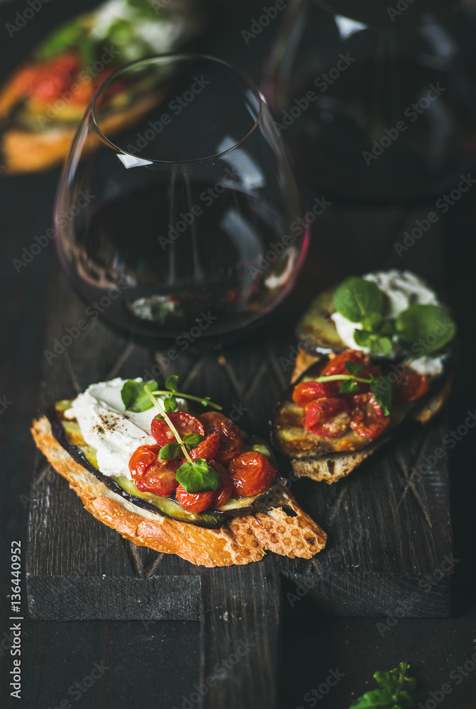 Wine and snack set. Brushetta with roasted eggplant, tomatoes, garlic, cream cheese, arugula and gla