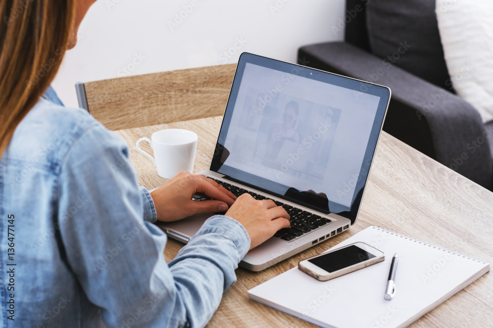 Back view portrait of a casual businesswoman working on laptop i