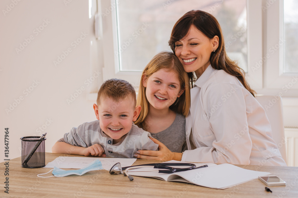 Doctor with kids in office, smiling