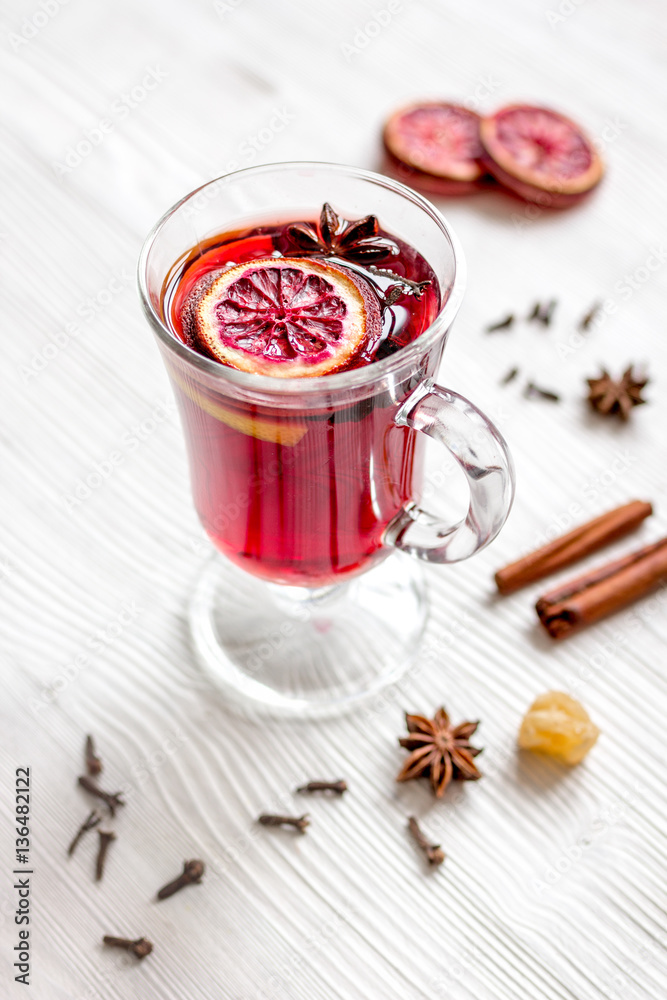 mulled wine with spices in cup on wooden background