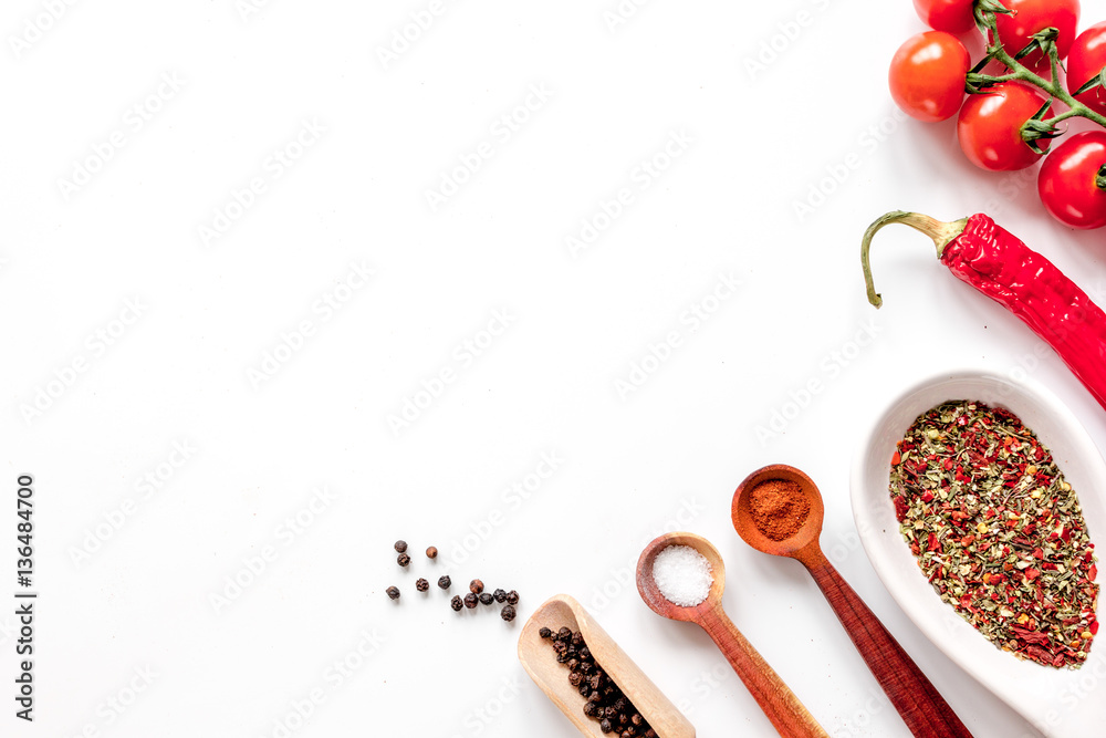 spices in wooden spoon on white background top view