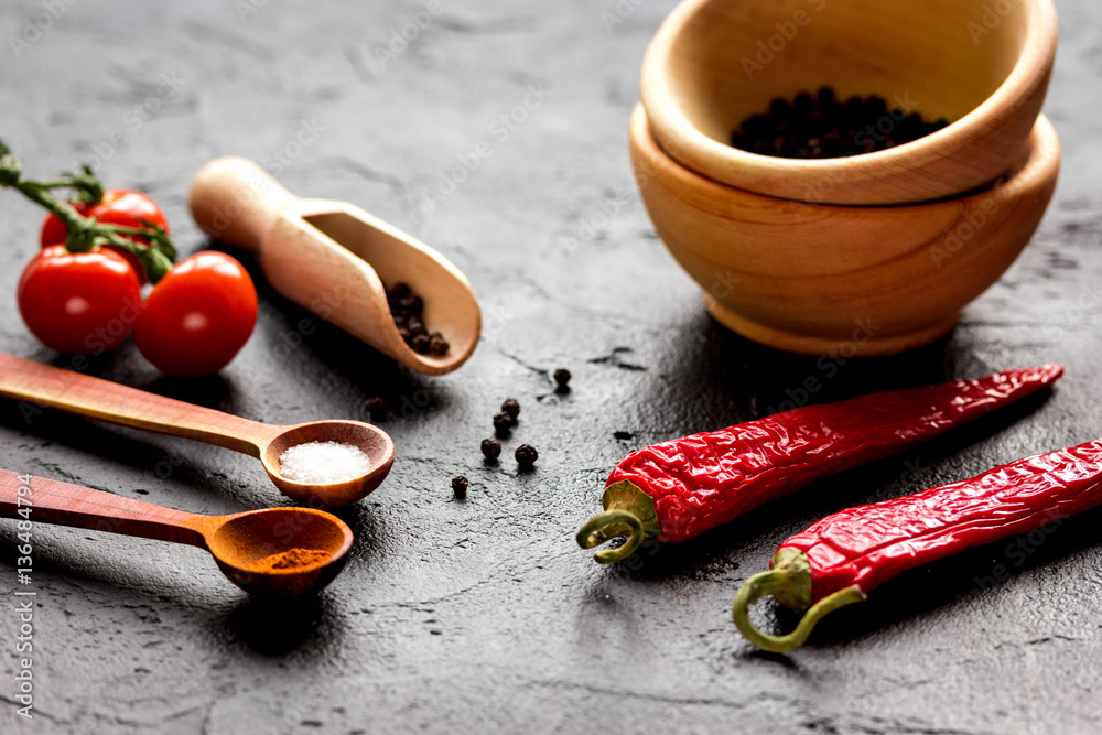 spices in wooden spoon on dark background