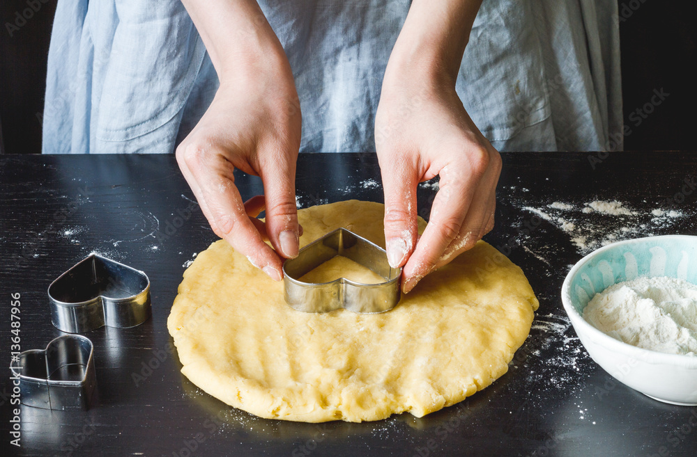 cooking homemade cookies with hands on dark background