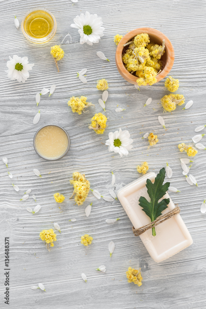 organic cosmetics with camomile on wooden background top view