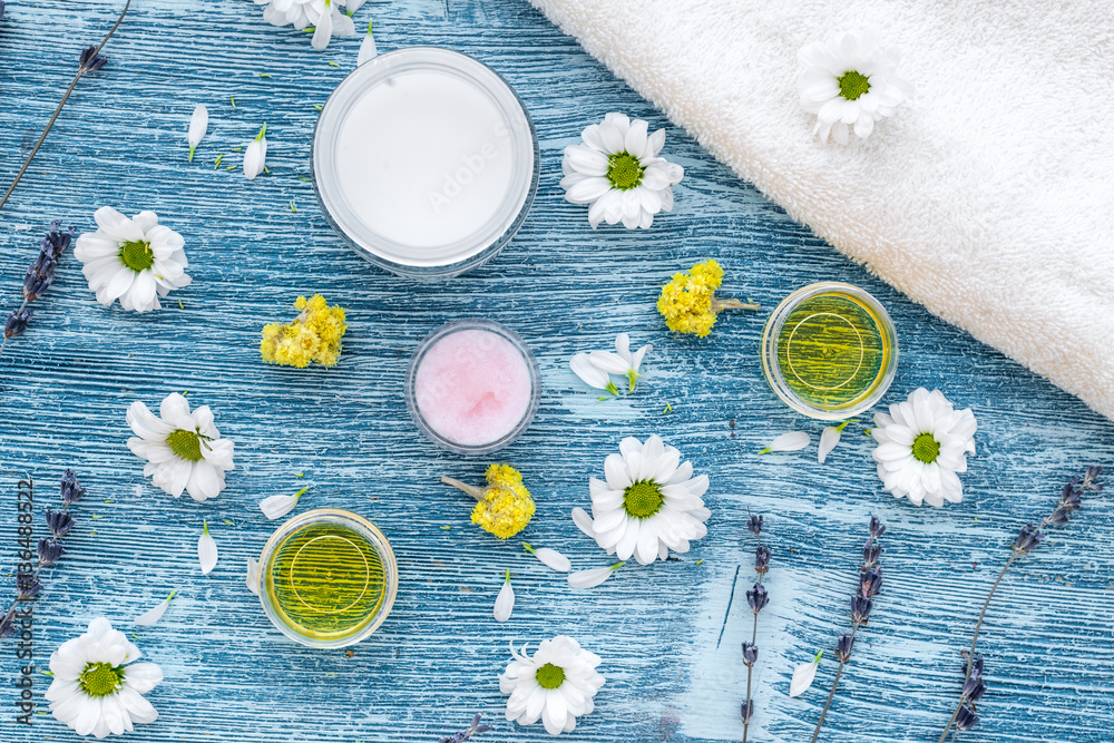 organic cosmetics with camomile on blue background top view