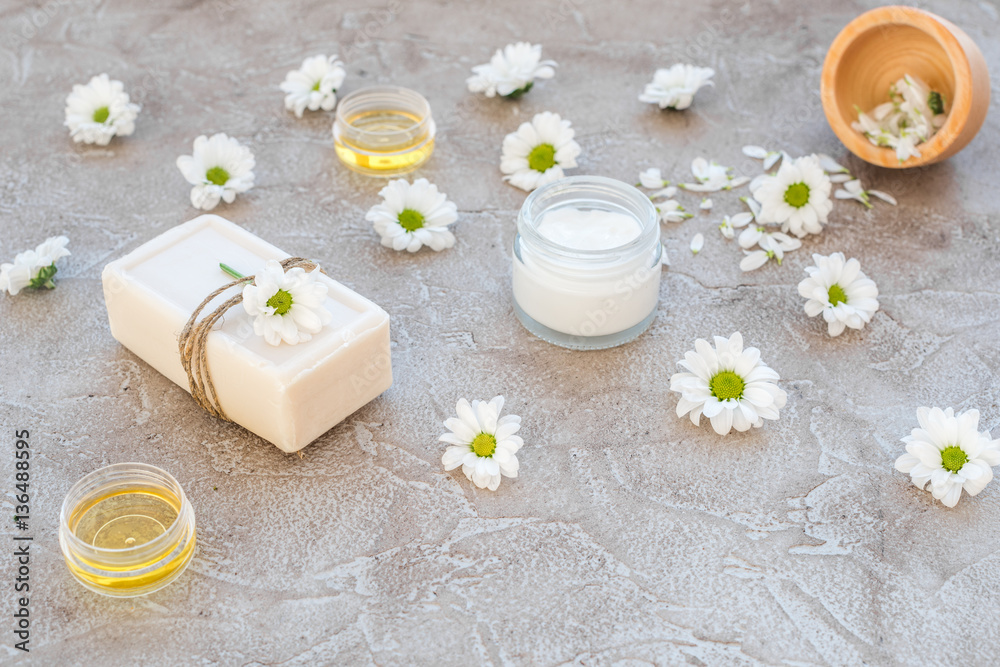 organic cosmetics with camomile on stone background