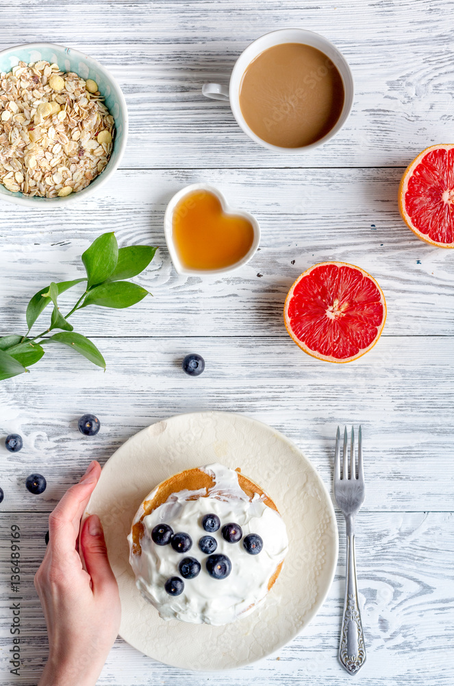 Breakfast concept with flowers on wooden background top view