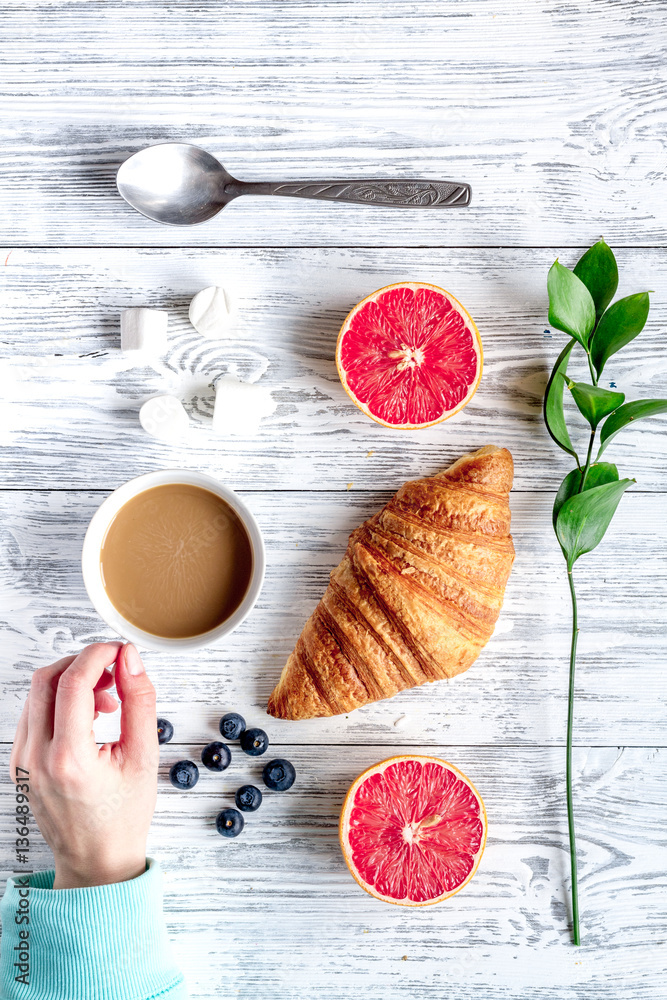 Breakfast concept with flowers on wooden background top view