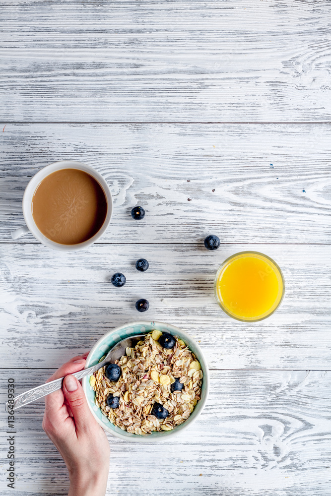 Breakfast concept with flowers on wooden background top view