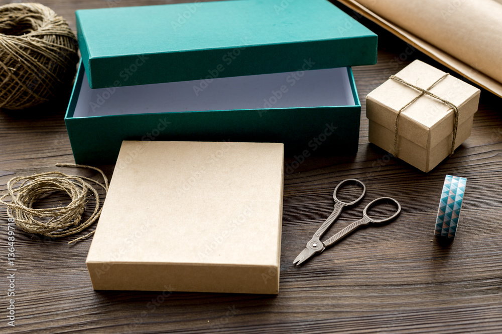 wrapping gifts in box for holiday on wooden background