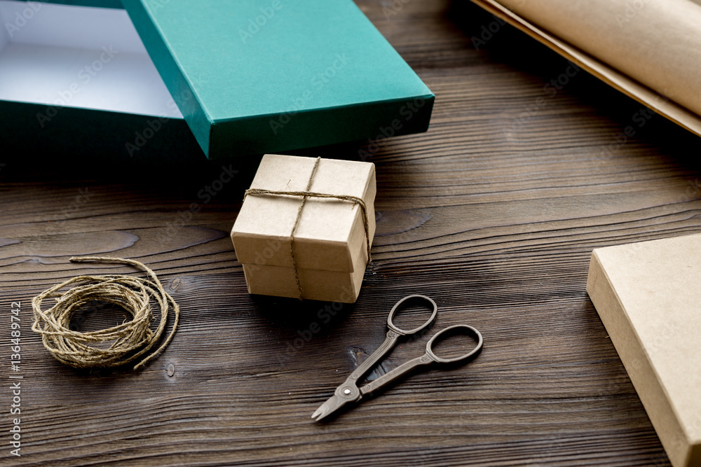 wrapping gifts in box for holiday on wooden background