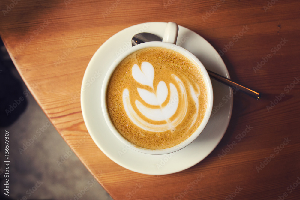 Cup of coffee on wooden table in cafe. Top view