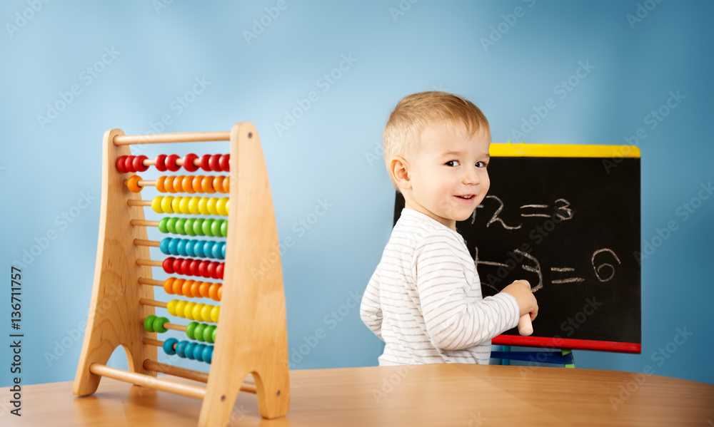 Child writing numbers on chalkboard