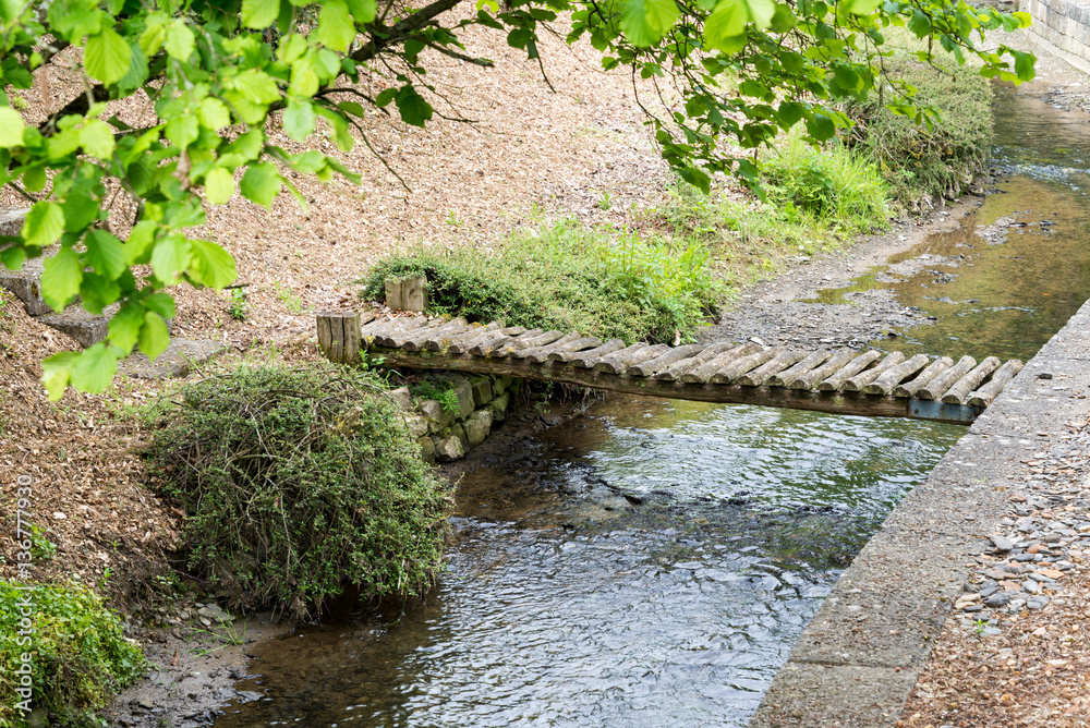 Petit pont de bois au dessus dun ruisseau à labri des regards. Promenade et détente.